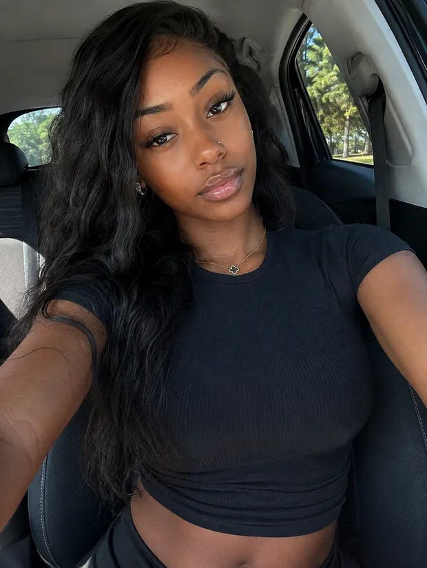 A casual phone selfie of a shopper in a car, wearing a black top