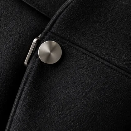 Black wool coat, a brushed-steel button on the seam